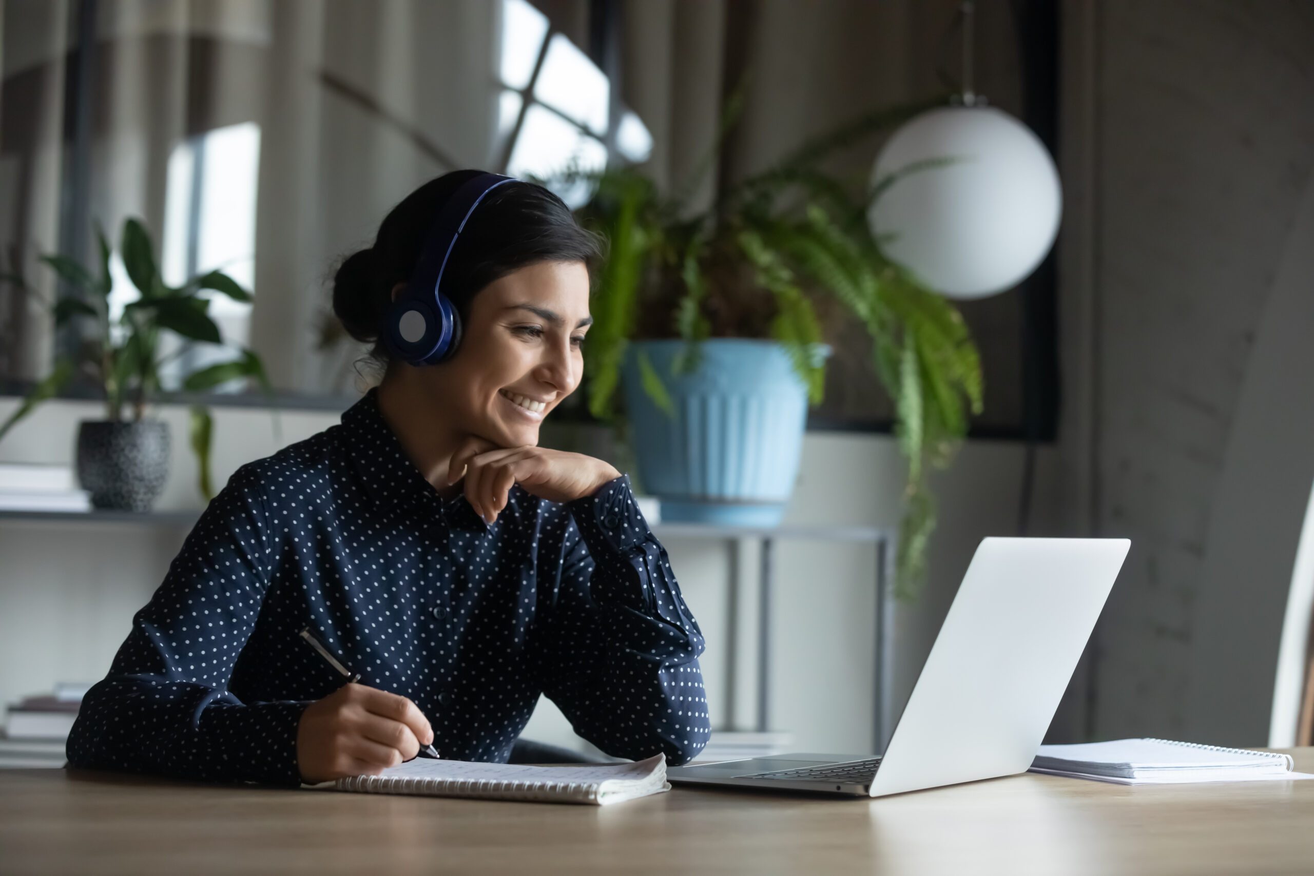 happy,young,indian,girl,with,wireless,headphones,looking,at,laptop